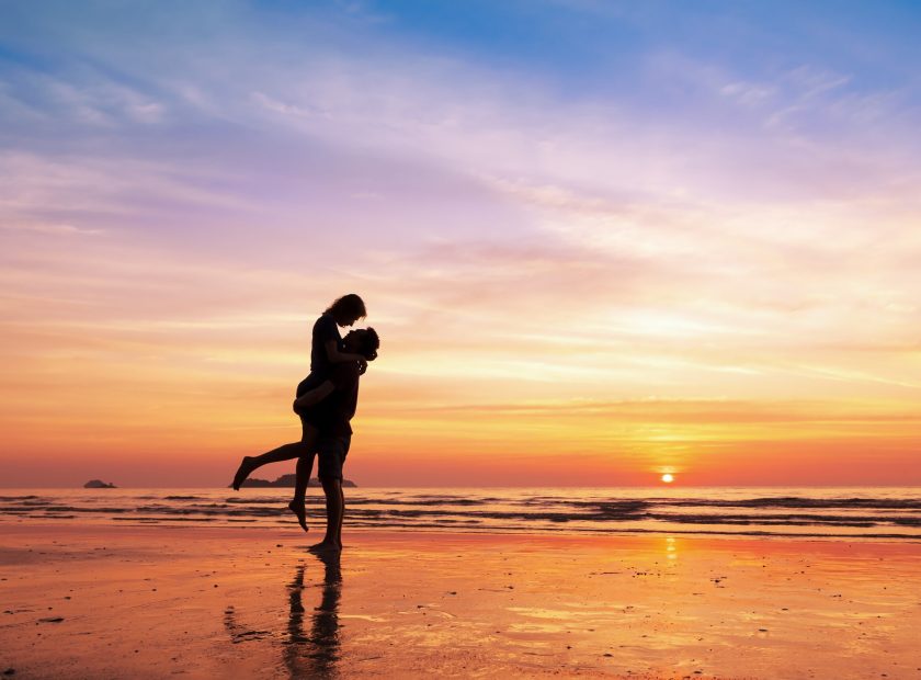 Couple,Kissing,On,The,Beach,With,A,Beautiful,Sunset,In